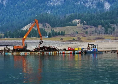 Skemxist Solutions Equipment Tug Boat Moving Barge with Long Boom Excavator Doing Log Dewatering